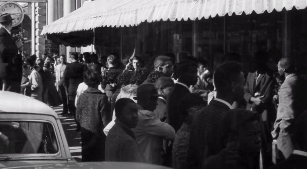 crowd standing in front of store with lunch counter