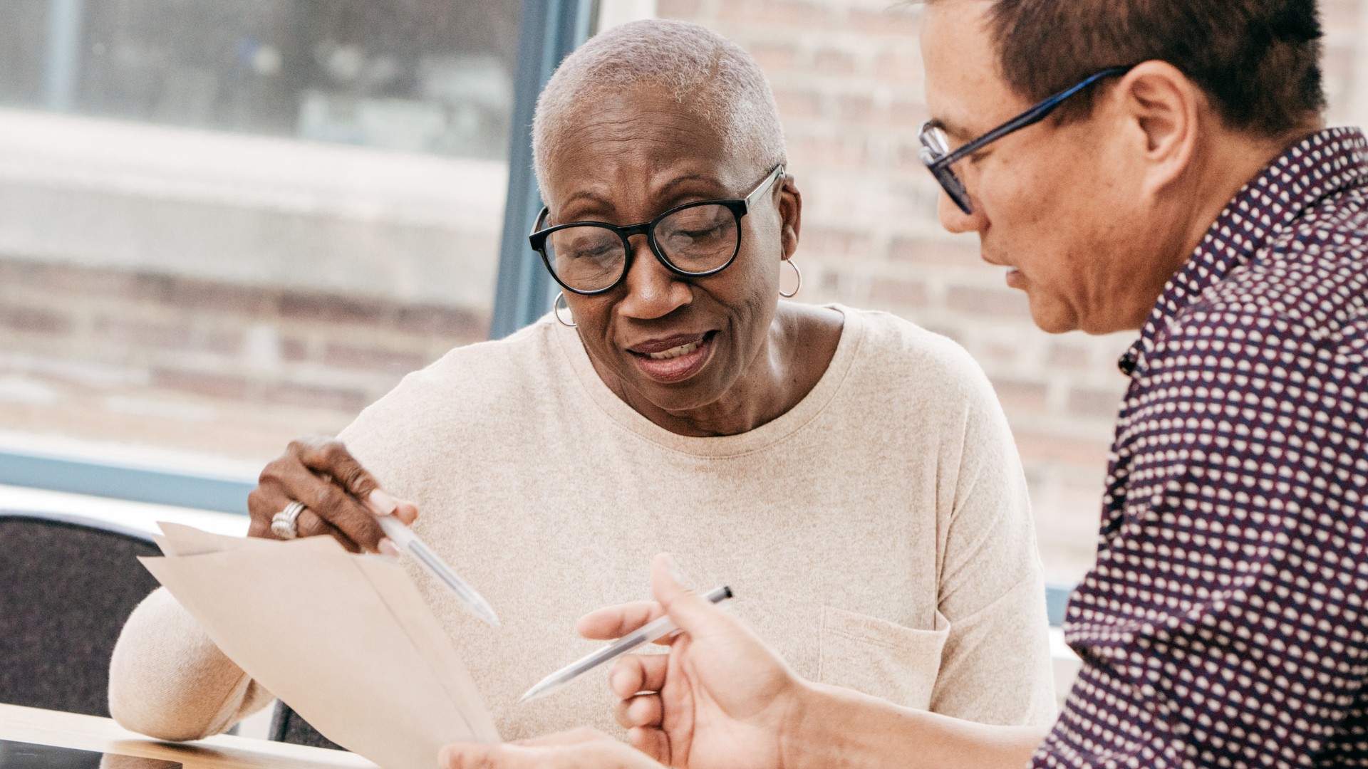 African American woman with a man signing a document