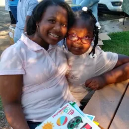 photo of mother and child holding Smart Cat stickers at an event