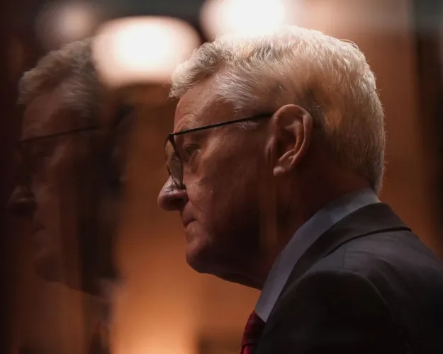 Treasurer Curtis Loftis seen through a Senate antechamber window after delivering remarks during the hearing for his removal from office in the South Carolina Senate on April 21, 2025.