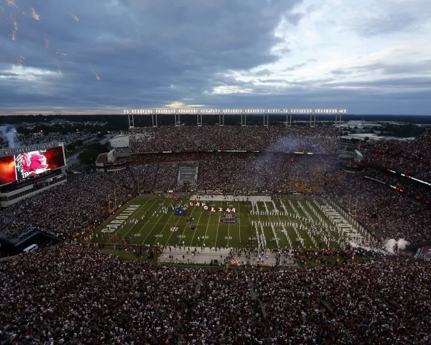 FILE - Fans cheer as South Carolina takes the field at William-Brice Stadium before the start of an NCAA college football game against Missouri, Sept. 27, 2014, in Columbia, S.C. Eddie Dunning, who painted the South Carolina Gamecock logo at midfield in Williams-Brice Stadium for 40 seasons, has died, university officials said Wednesday, July 17, 2024. (AP Photo/Stephen B. Morton, File)