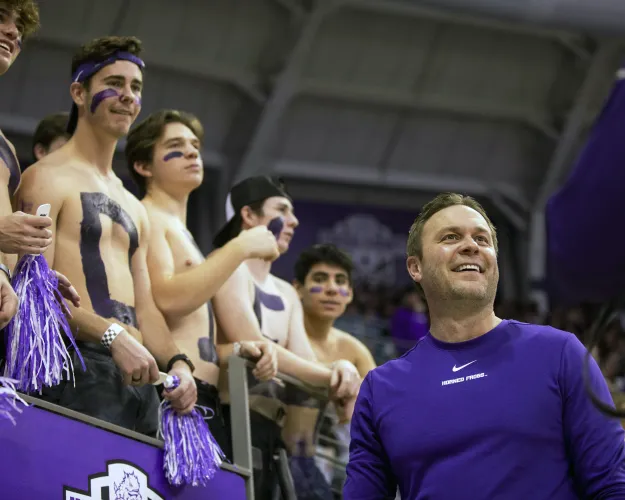 TCU athletic director Jeremiah Donati celebrates with fans before an NCAA college basketball game between TCU and Texas in Fort Worth, Texas, Tuesday, Jan. 25, 2022. (AP Photo/Gareth Patterson)