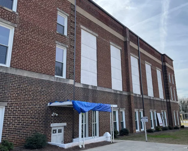 The grand windows of New Mt. Olivet AME Zion Church used to greet drivers heading into Rock Hill's historic Southside neighborhood. Since the April hailstorm, boards protect against the elements in place of the large glass panes. The church is among several properties in this end of town that are still waiting to repair damage from the hailstorm and, later, from Tropical Storm Helene.