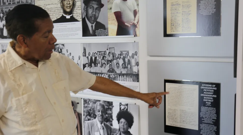 Cecil Williams in front of the Briggs-Delaine exhibit at his museum