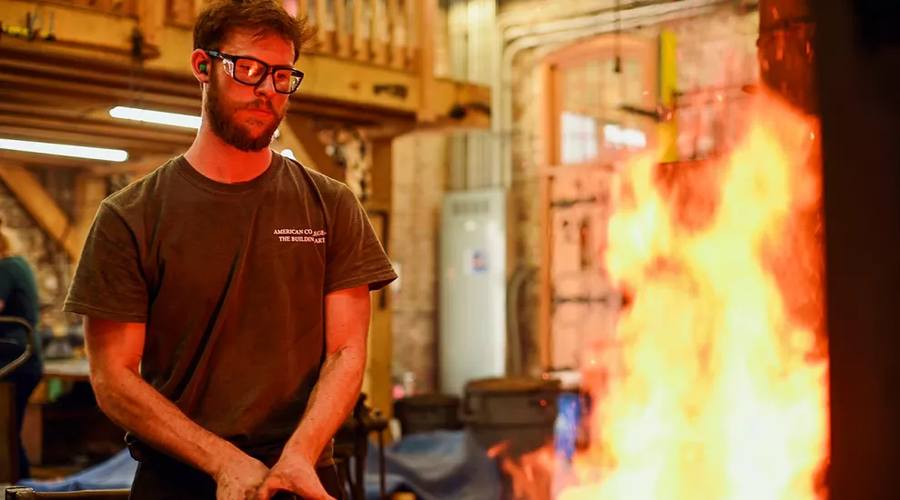 Photo of a student at the American College of Building Arts using a Blacksmith's forge.