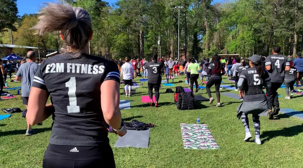 Image of a group working out to E2M Fitness outside in a park.