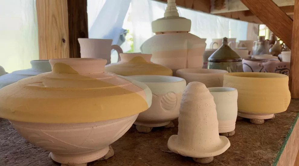 Image of hand made pottery waiting to be fired in a kiln.