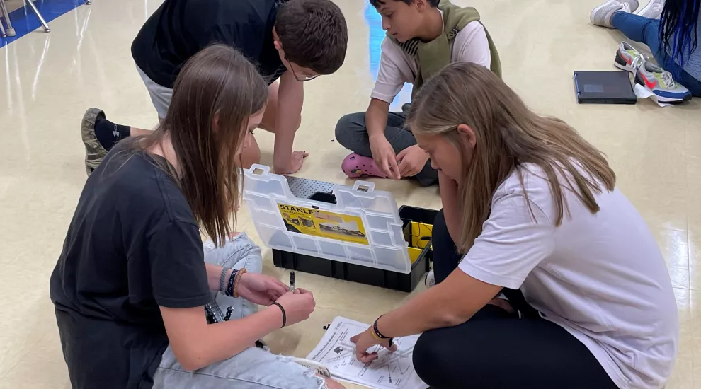 Students sitting on the floor in a classroom