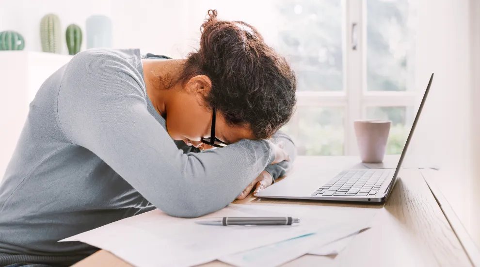 photo of stressed woman with her head down at her laptop