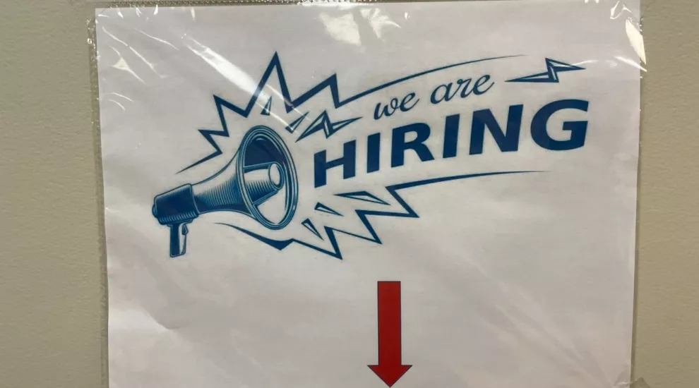 photo of a sign with the words "We Are Hiring"