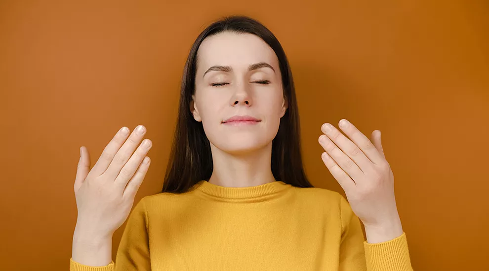 Woman taking a deep breath and relaxing with eyes closed