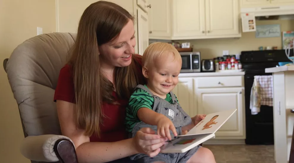 Grace Balding reads a book to her toddler