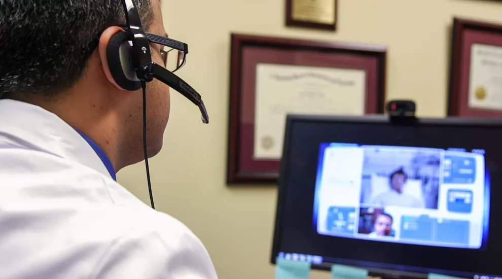 A doctor connects to a rural hospital from his office through telehealth.