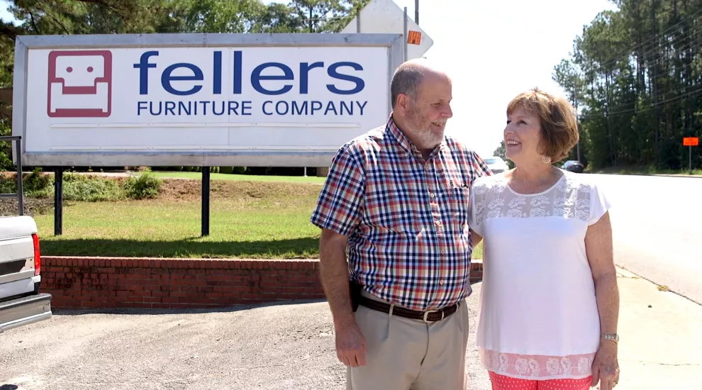 Johnny Fellers and his wife in front of furniture store