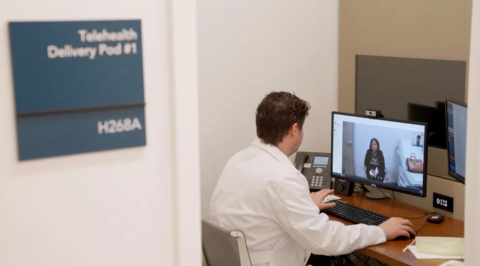 Chad Davis, MSN, FNP-BC, meets with kidney transplant patient Calandra Watkins during a telehealth visit. 