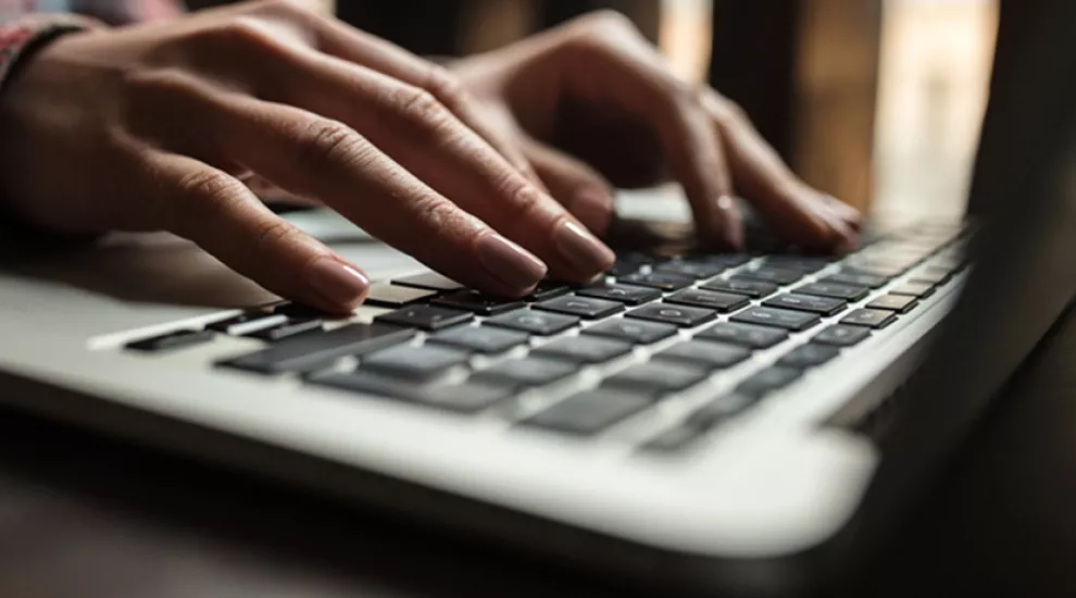 Pair of hands typing on keyboard