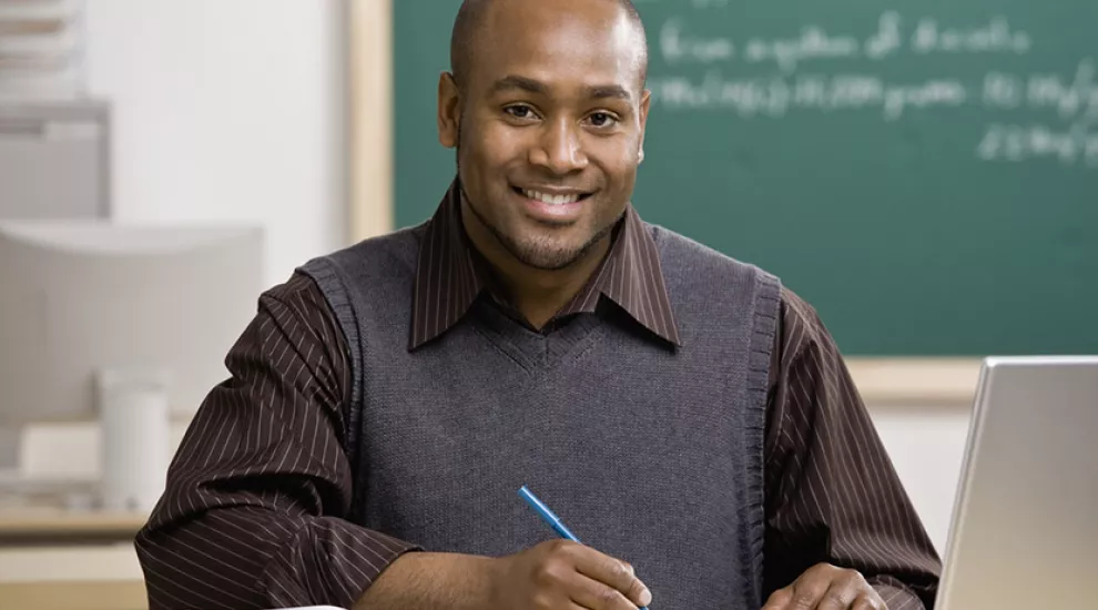 image of male teacher sitting with a laptop