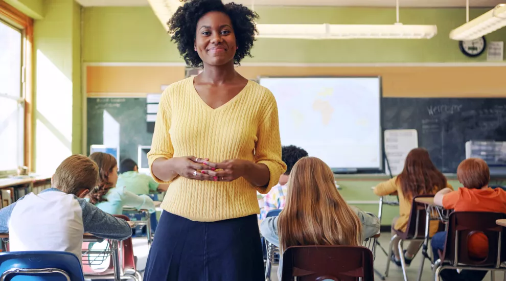 smiling teacher standing in classroom