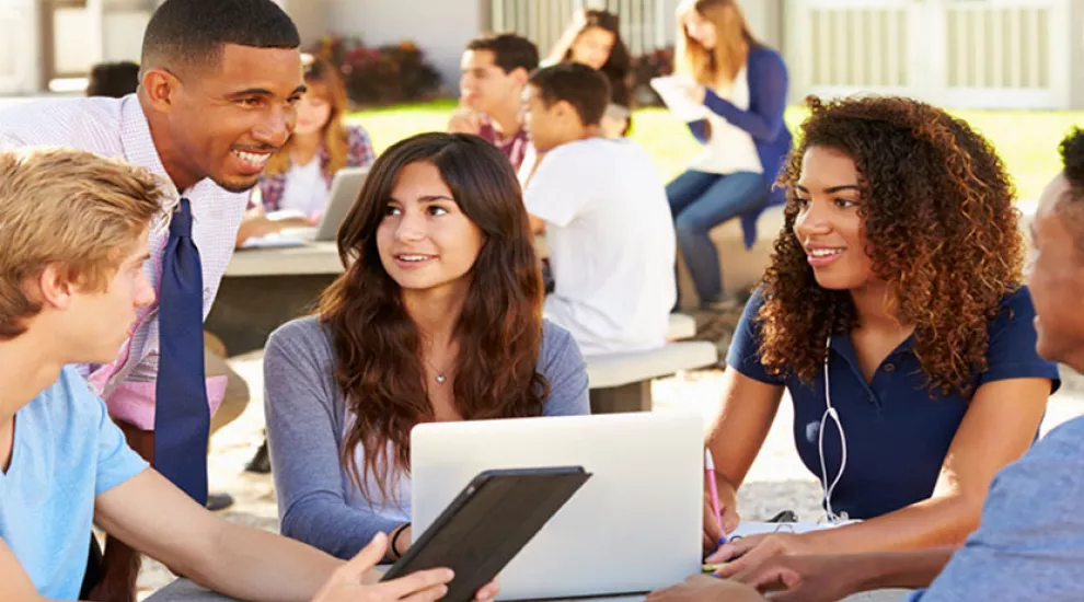 Teacher with students on laptops and tablets