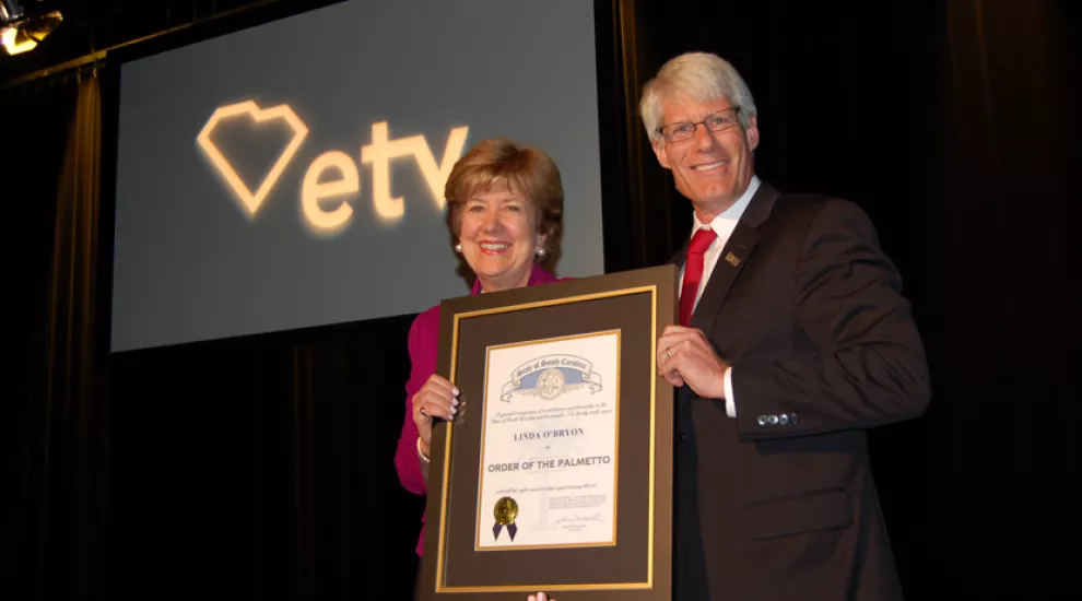 Linda O'Bryon accepts the Order of the Palmetto from Dr. Brent Nelsen