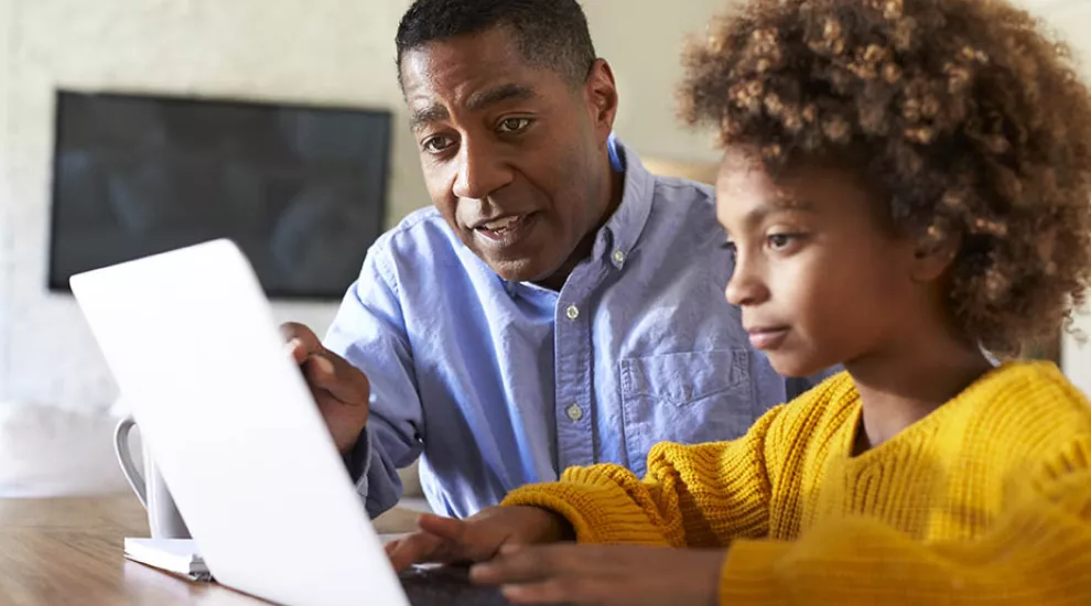 Father helping daughter with school work