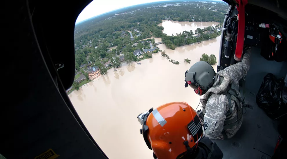 National Guardsmen in helicoper observe flooded river