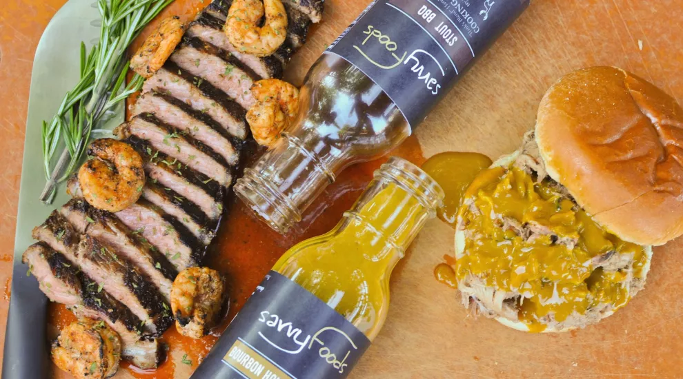 savvy foods bottles with steak, shrimp and barbecue sandwich