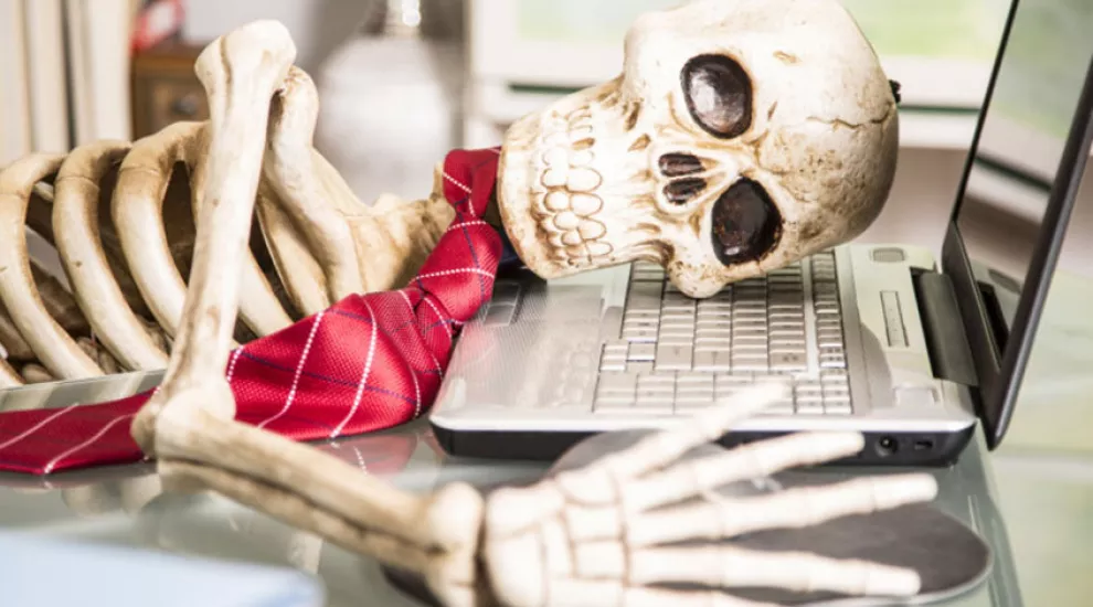 image of skeleton with head on laptop