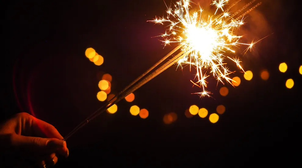 photo showing a hand holding a sparkler