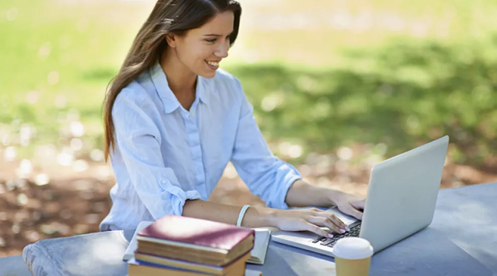 Teacher outside taking course on laptop