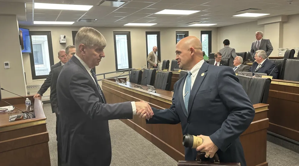 Dr. Edward Simmer, left, the nominee to be the first director of the South Carolina Department of Public Health, shakes the hand of South Carolina Sen. Tom Fernandez, R-Summerville, right, on Thursday, March 20, 2025, in Columbia, S.C. (AP Photo/Jeffrey Collins)