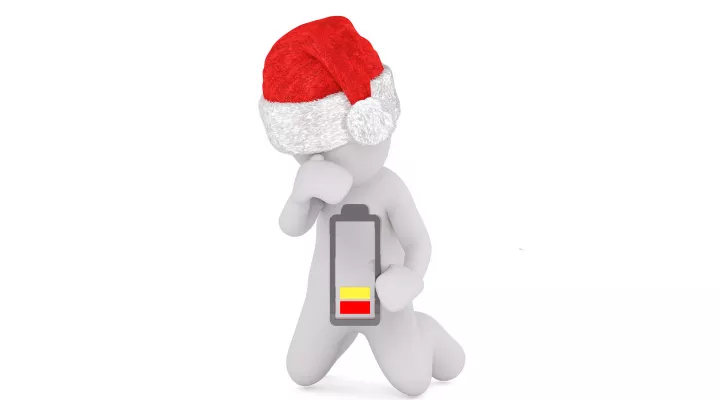 illustration of a male figure in a Santa who is holding a battery that is "low" on power