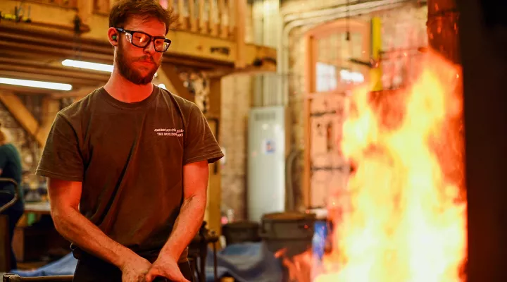 Photo of a student at the American College of Building Arts using a Blacksmith's forge.