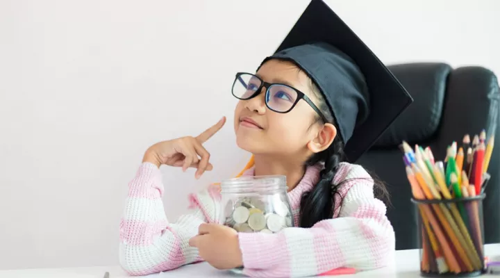 Girl with jar of money - looking up and smiling like she has an idea