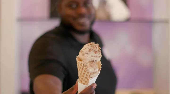 Owner of Park Circle Creamery Maurice Ray holding a cone of ice cream