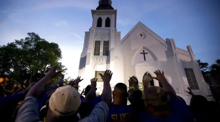 The men of Omega Psi Phi Fraternity Inc., lead a crowd of people in prayer outside the Emanuel AME Church on June 19, 2015, after a memorial in Charleston, S.C. (AP Photo/Stephen B. Morton, File)