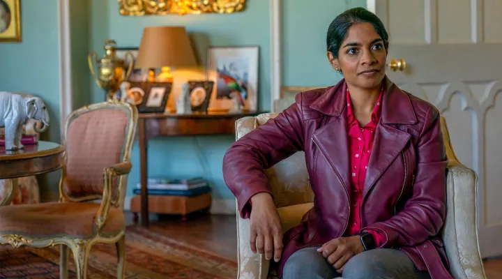 Woman sitting in a chair wearing burgundy leather jacket