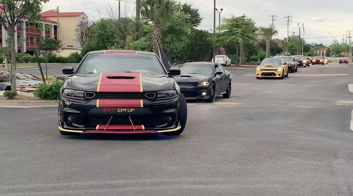 Photograph showing a convoy of Dodge Charger and Dodge Challenger cars.