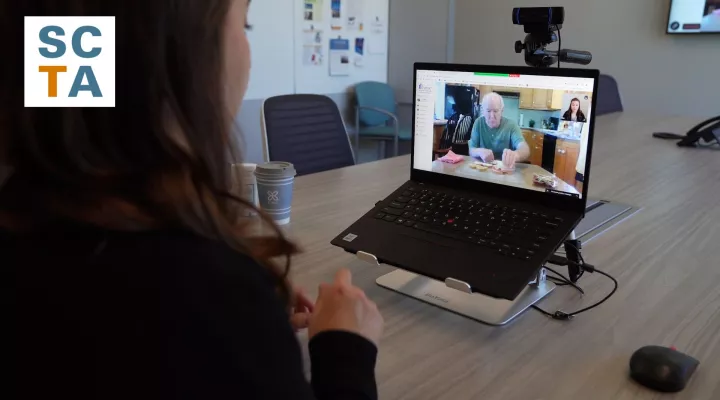 Woman in front of a laptop talking to person on screen