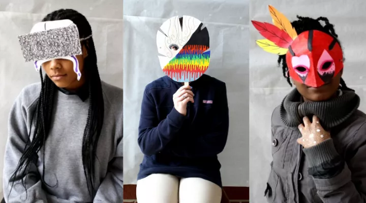 image of 3 students holding up art masks they made