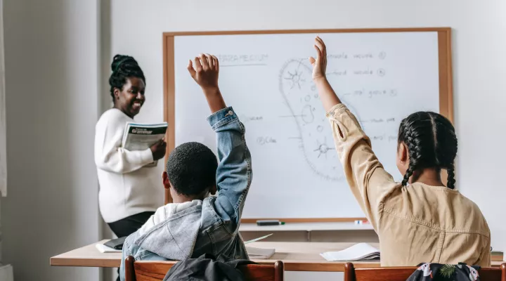 photo of teacher with 2 students in classroom