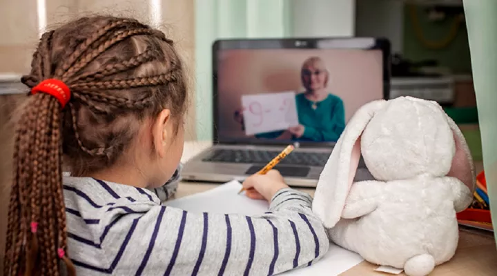 young girl learning math via a laptop