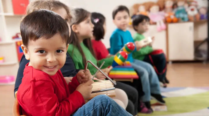 photo of several children sitting together playing with musical instruments