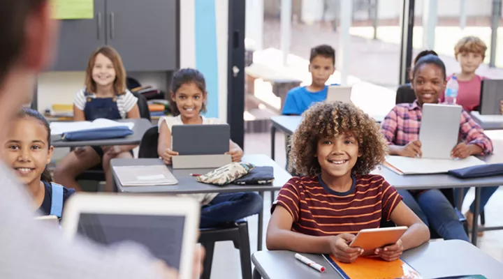 Teacher in front of classroom of students with tablets