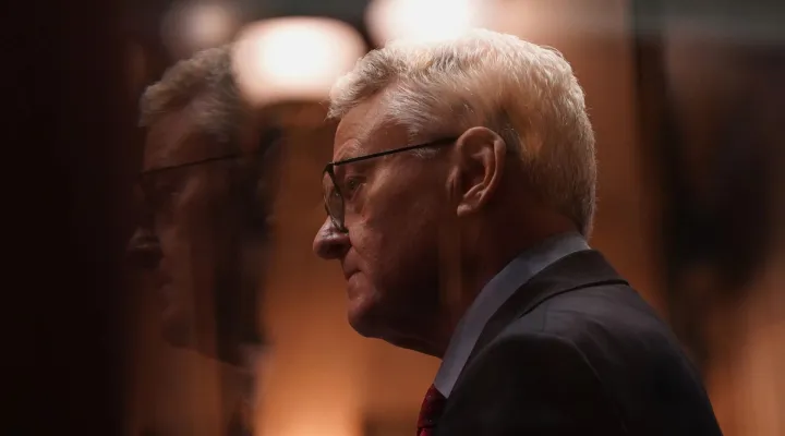 Treasurer Curtis Loftis seen through a Senate antechamber window after delivering remarks during the hearing for his removal from office in the South Carolina Senate on April 21, 2025.
