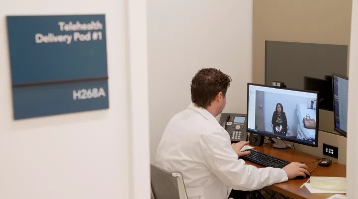 Chad Davis, MSN, FNP-BC, meets with kidney transplant patient Calandra Watkins during a telehealth visit. 