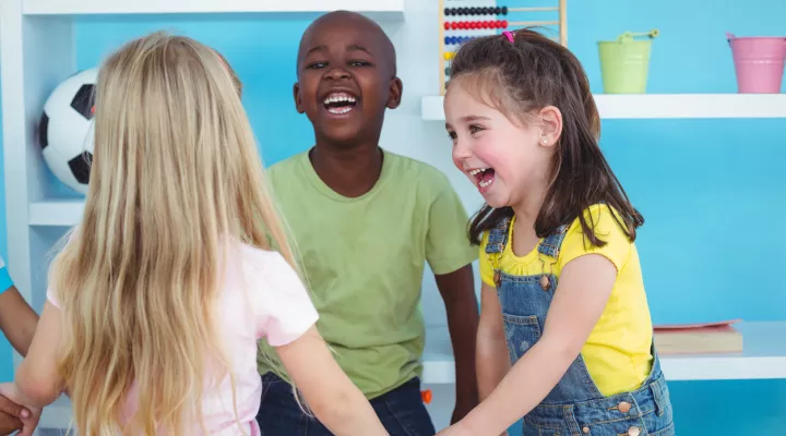 photo of young children holding hands and smiling