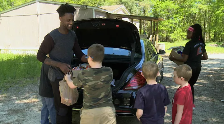 Dontrelle Inman passes groceries to children