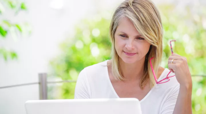 woman sitting outside looking at laptop screen