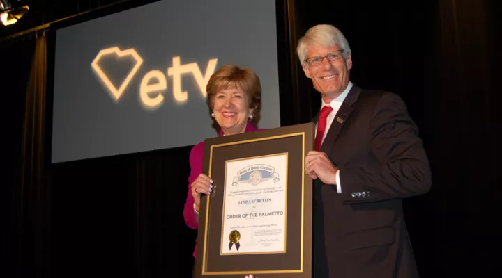 Linda O'Bryon accepts the Order of the Palmetto from Dr. Brent Nelsen